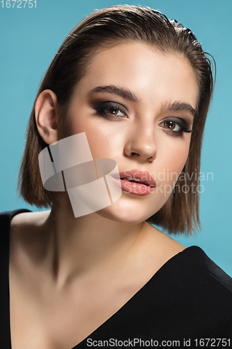 Image of Portrait of female fashion model isolated on blue studio background. Style and beauty concept. Close up.