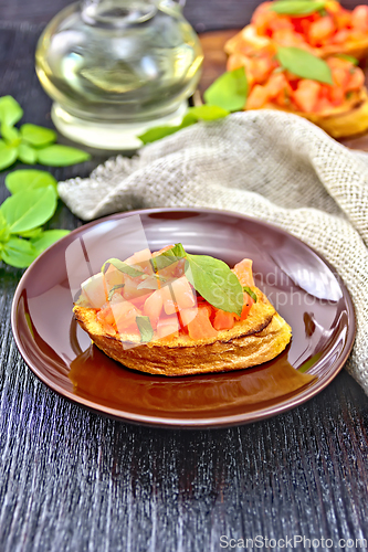Image of Bruschetta with tomato and basil in plate on board