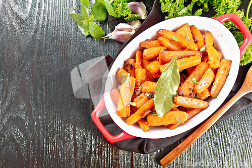 Image of Carrots fried in pan on dark board top