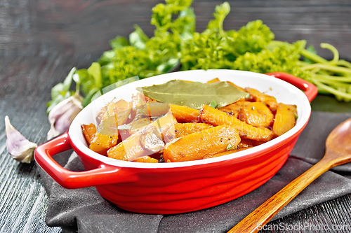 Image of Carrots fried in pan on dark board