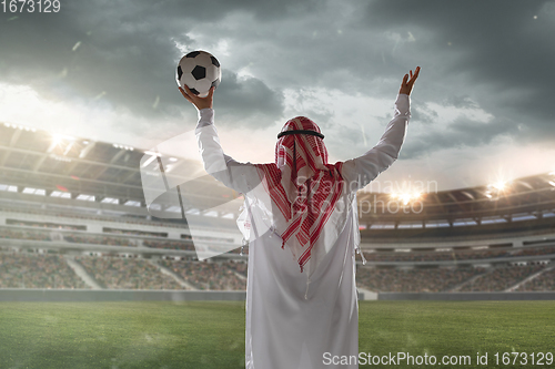 Image of Arabian businessman back view standing on his stadium during sport match