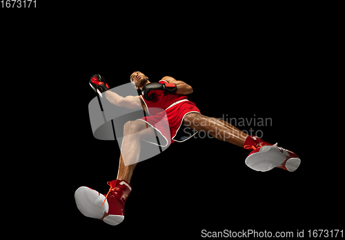 Image of Young african-american boxer in action, motion isolated on black background, look from the bottom. Concept of sport, movement, energy and dynamic.