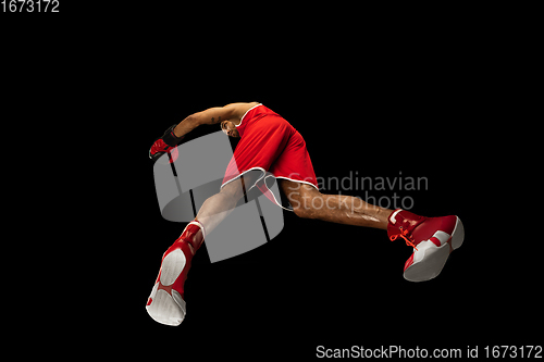 Image of Young african-american boxer in action, motion isolated on black background, look from the bottom. Concept of sport, movement, energy and dynamic.