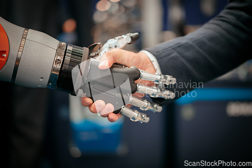 Image of Hand of a businessman shaking hands with a Android robot.