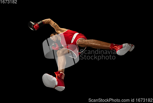 Image of Young african-american boxer in action, motion isolated on black background, look from the bottom. Concept of sport, movement, energy and dynamic.