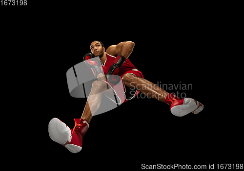 Image of Young african-american boxer in action, motion isolated on black background, look from the bottom. Concept of sport, movement, energy and dynamic.