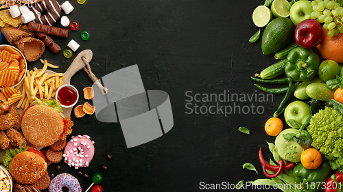 Image of Fast and healthy food compared on black stone background. Unhealthy set including burgers, sauces, french fries in comparison with vegetables, fruits, organic food