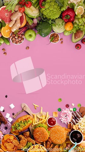 Image of Fast and healthy food compared on pink background. Unhealthy set including burgers, sauces, french fries in comparison with vegetables, fruits, organic food