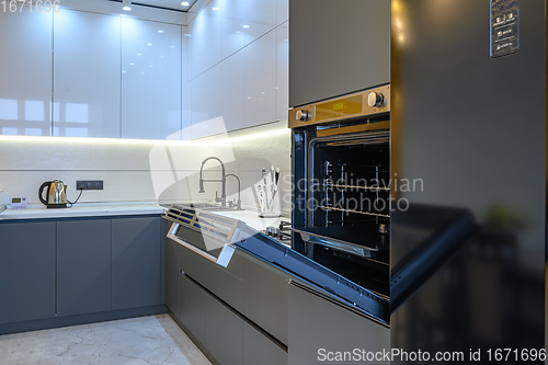 Image of Luxury gray modern kitchen interior, oven\'s door opened