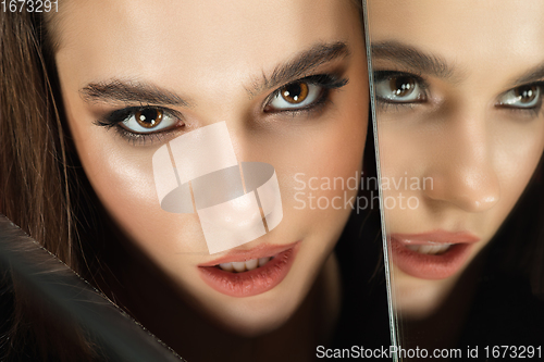 Image of Portrait of female fashion model with reflections on mirrors around her face. Style and beauty concept. Close up.