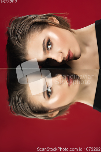 Image of Portrait of female fashion model with reflections on mirrors around her face. Style and beauty concept. Close up.