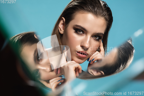 Image of Portrait of female fashion model with reflections on mirrors around her face. Style and beauty concept. Close up.