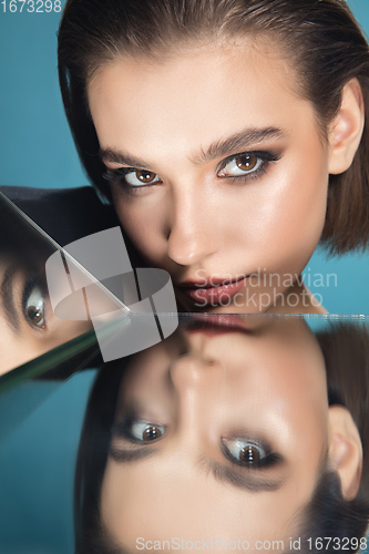 Image of Portrait of female fashion model with reflections on mirrors around her face. Style and beauty concept. Close up.