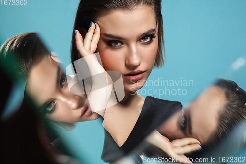 Image of Portrait of female fashion model with reflections on mirrors around her face. Style and beauty concept. Close up.