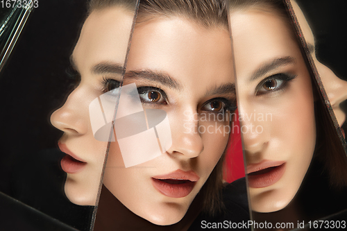 Image of Portrait of female fashion model with reflections on mirrors around her face. Style and beauty concept. Close up.