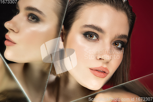 Image of Portrait of female fashion model with reflections on mirrors around her face. Style and beauty concept. Close up.