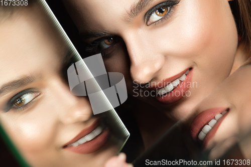 Image of Portrait of female fashion model with reflections on mirrors around her face. Style and beauty concept. Close up.