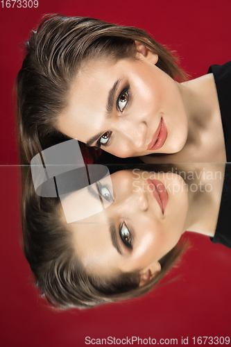 Image of Portrait of female fashion model with reflections on mirrors around her face. Style and beauty concept. Close up.