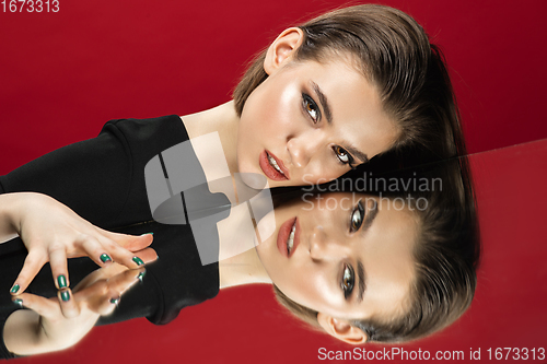 Image of Portrait of female fashion model with reflections on mirrors around her face. Style and beauty concept. Close up.