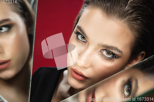 Image of Portrait of female fashion model with reflections on mirrors around her face. Style and beauty concept. Close up.