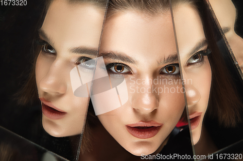 Image of Portrait of female fashion model with reflections on mirrors around her face. Style and beauty concept. Close up.
