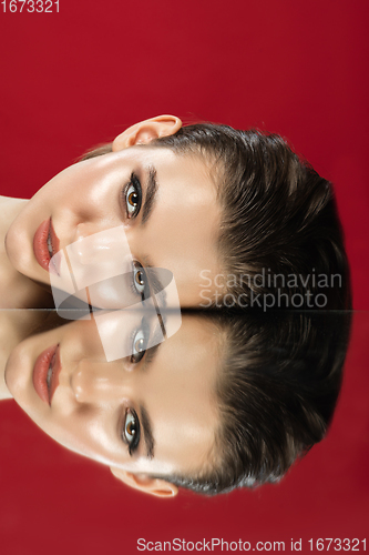 Image of Portrait of female fashion model with reflections on mirrors around her face. Style and beauty concept. Close up.