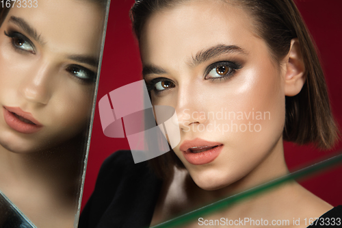 Image of Portrait of female fashion model with reflections on mirrors around her face. Style and beauty concept. Close up.