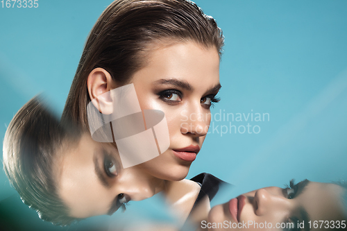 Image of Portrait of female fashion model with reflections on mirrors around her face. Style and beauty concept. Close up.