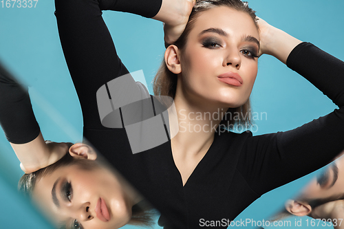 Image of Portrait of female fashion model with reflections on mirrors around her face. Style and beauty concept. Close up.