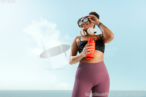 Image of Portrait of female fashion model on blue sky background. Style and beauty concept, bright appearance. Lifestyle sport.