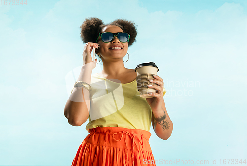 Image of Portrait of female fashion model on blue sky background. Style and beauty concept, bright appearance