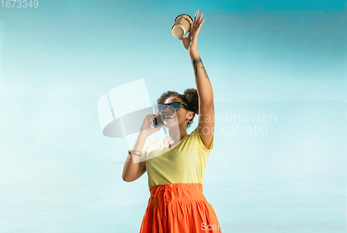 Image of Portrait of female fashion model on blue sky background. Style and beauty concept, bright appearance