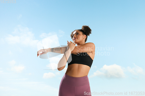 Image of Portrait of female fashion model on blue sky background. Style and beauty concept, bright appearance. Lifestyle sport.