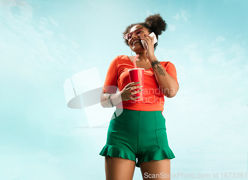 Image of Portrait of female fashion model on blue sky background. Style and beauty concept, bright appearance