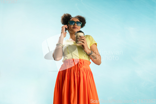 Image of Portrait of female fashion model on blue sky background. Style and beauty concept, bright appearance