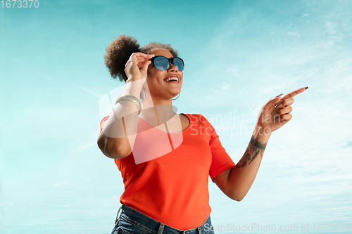 Image of Portrait of female fashion model on blue sky background. Style and beauty concept, bright appearance