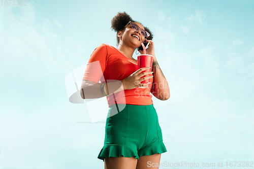 Image of Portrait of female fashion model on blue sky background. Style and beauty concept, bright appearance