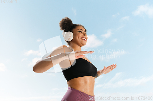 Image of Portrait of female fashion model on blue sky background. Style and beauty concept, bright appearance. Lifestyle sport.
