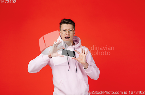 Image of Caucasian man\'s portrait isolated on red studio background with copyspace