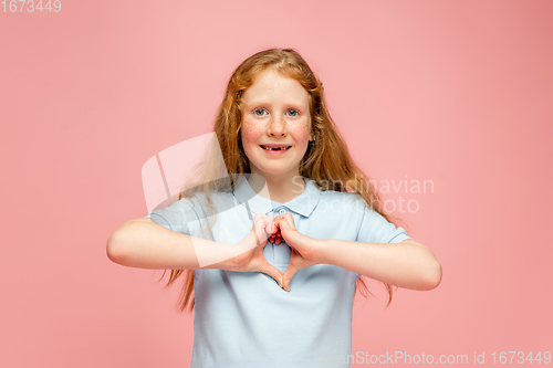 Image of Happy redhair girl isolated on pink studio background. Looks happy, cheerful, sincere. Copyspace. Childhood, education, emotions concept