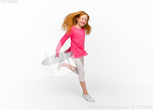 Image of Happy redhair girl isolated on white studio background. Looks happy, cheerful, sincere. Copyspace. Childhood, education, emotions concept