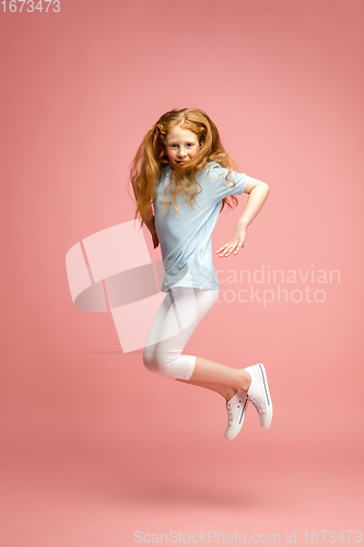 Image of Happy redhair girl isolated on pink studio background. Looks happy, cheerful, sincere. Copyspace. Childhood, education, emotions concept