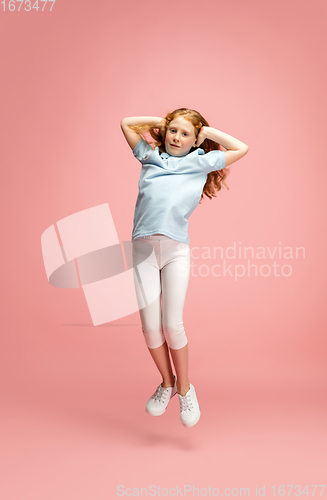 Image of Happy redhair girl isolated on pink studio background. Looks happy, cheerful, sincere. Copyspace. Childhood, education, emotions concept