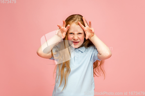 Image of Happy redhair girl isolated on pink studio background. Looks happy, cheerful, sincere. Copyspace. Childhood, education, emotions concept