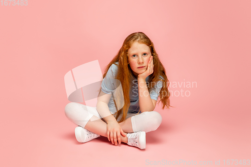 Image of Happy redhair girl isolated on pink studio background. Looks happy, cheerful, sincere. Copyspace. Childhood, education, emotions concept