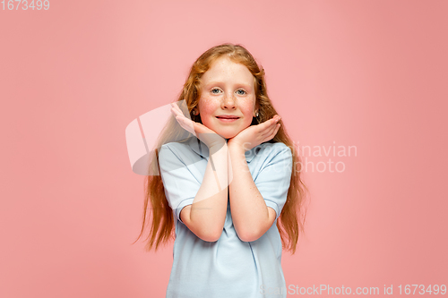 Image of Happy redhair girl isolated on pink studio background. Looks happy, cheerful, sincere. Copyspace. Childhood, education, emotions concept