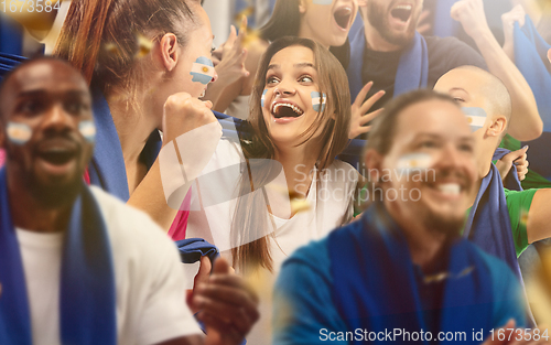 Image of Argentinian football, soccer fans cheering their team with a blue scarfs at stadium. Excited fans cheering a goal, supporting favourite players