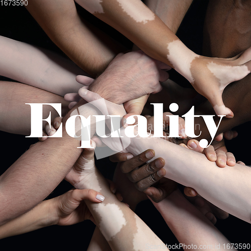 Image of African and caucasian hands gesturing on gray studio background, tolerance and equality concept