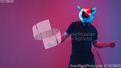 Image of Talented dog, professional musician performing on multicoloted background in neon light. Concept of music, hobby, festival, contemporary art collage. Modern design.