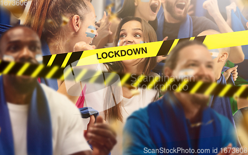 Image of Argentinian soccer fans cheering for favourite sport team with bright emotions, excited, wondered behind the limiting tapes with Lockdown